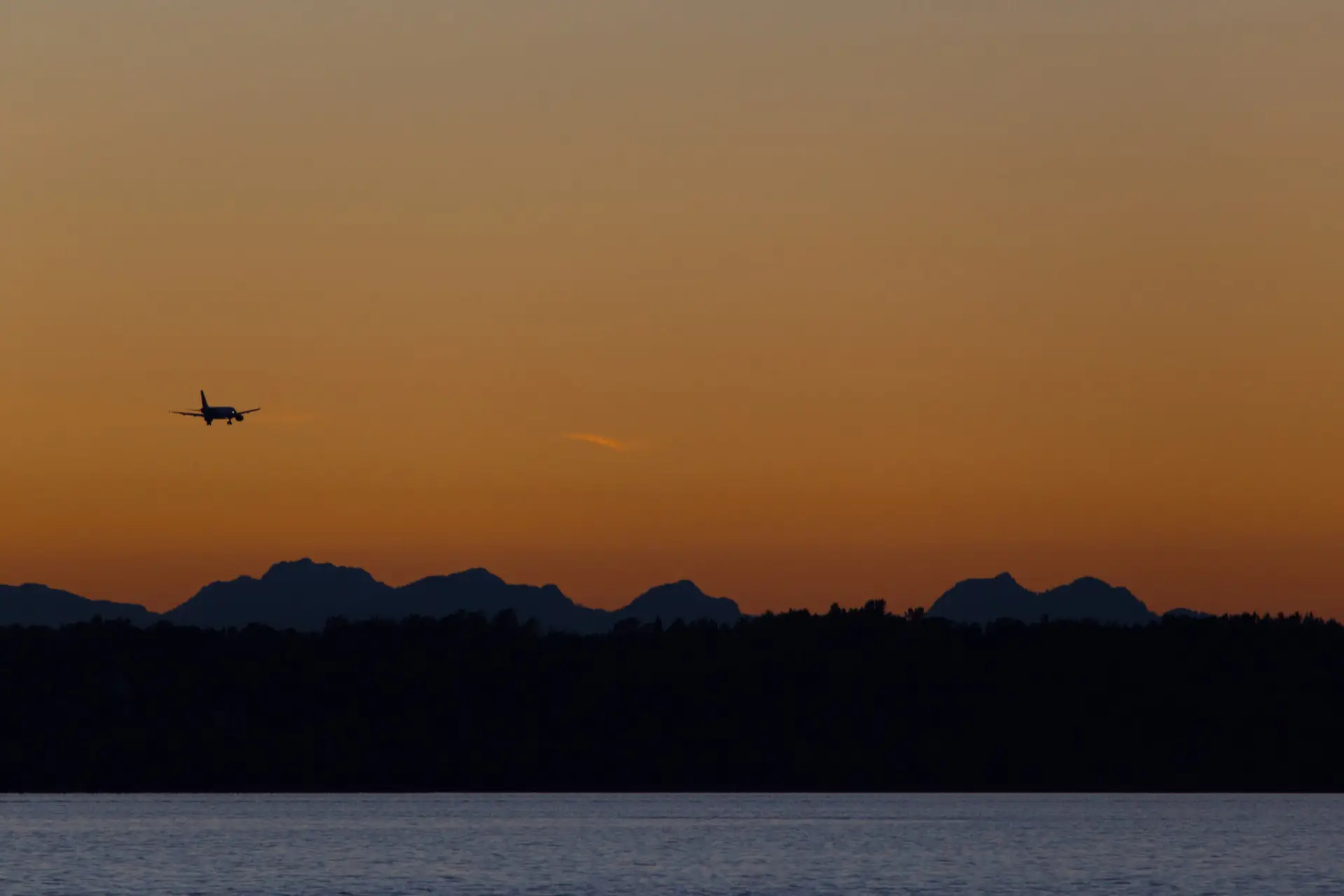 Avión sobrevolando en el atardecer.