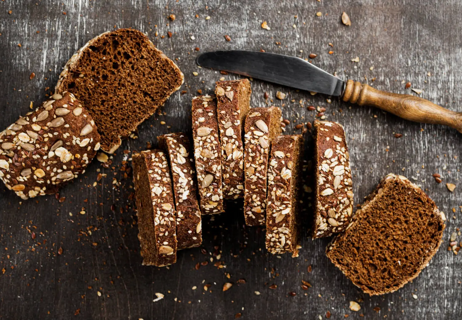 Must leib de Estonia, conocido como pan negro en español. Pan de centeno cortado a rebanadas junto a un cuchillo de madera.